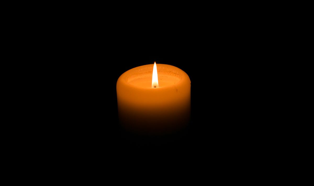 a candle illuminates a dark background