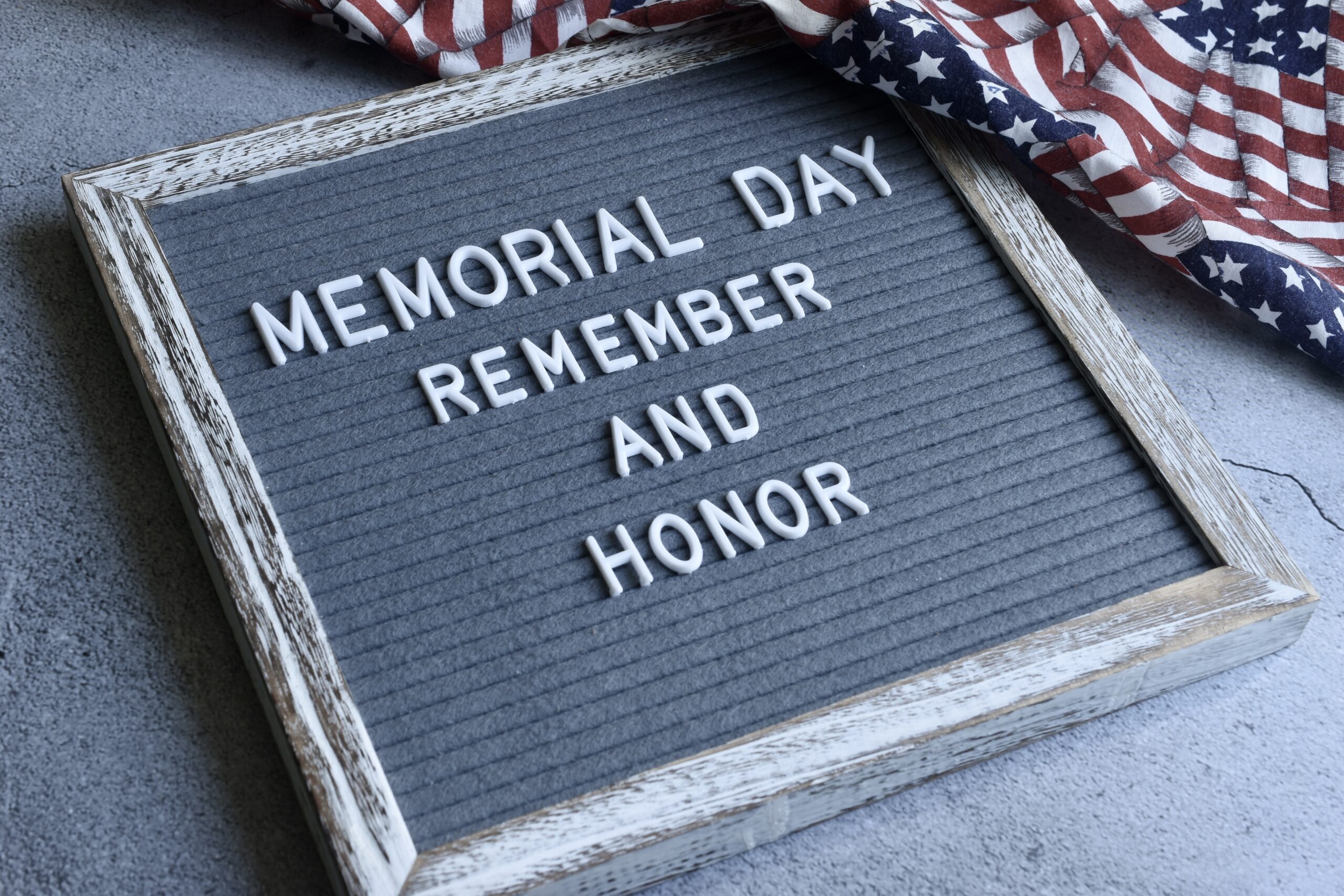 Memorial Day: remember an honor is written on a plaque beside the American flag